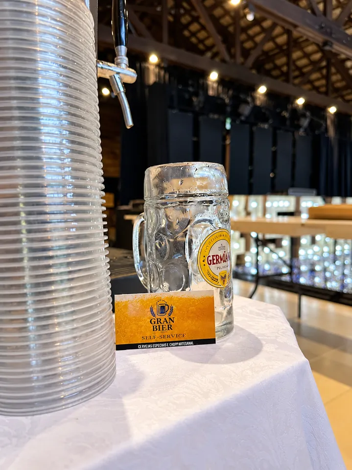 Caneca Germania e cartão Gran Bier ao lado dos copos