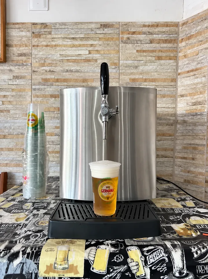 Chopeira de inox com um copo de chopp servido